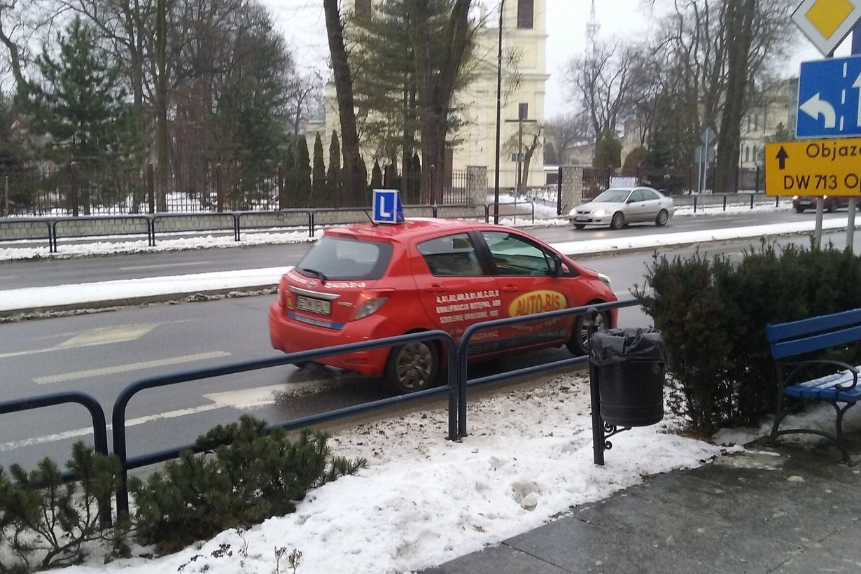 Samochód szkoły nauki jazdy z literą L podczas jazdy szkoleniowej na ulicy w Tomaszowie Mazowieckim